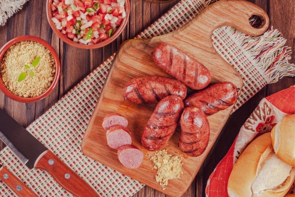 Linguiça assada na brasa em cima de uma tábua de madeira 