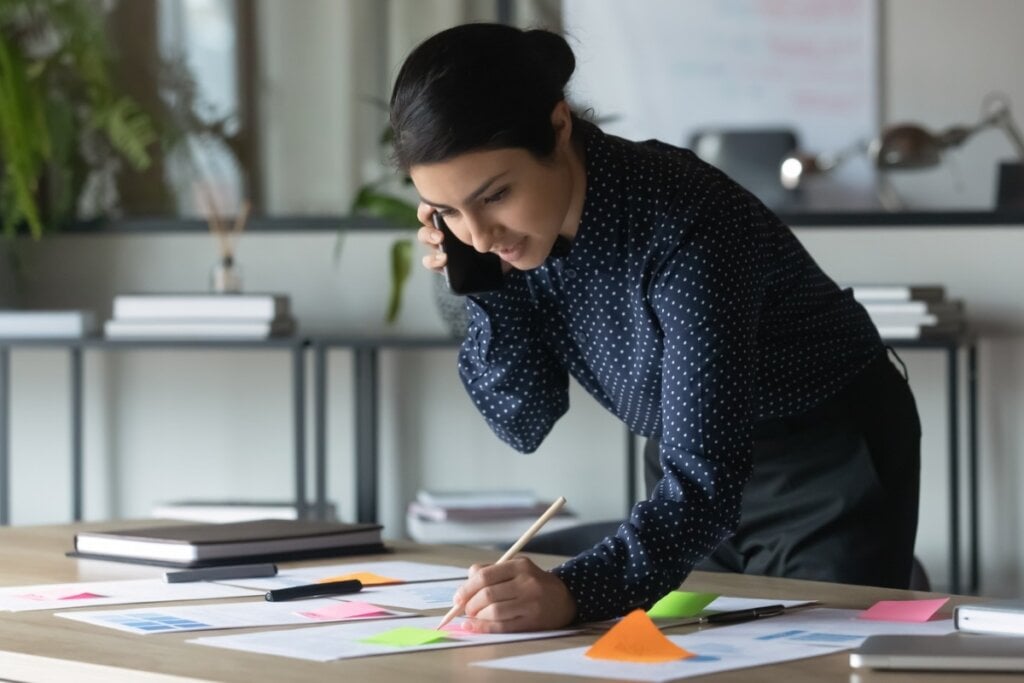 Mulher em um escritório organizando os horários em post-its 