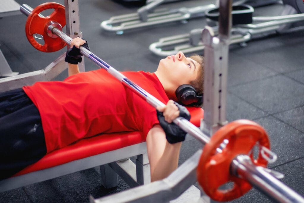 Adolescente em uma academia fazendo musculação