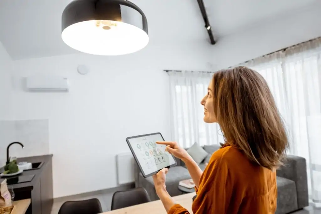 Jovem controlando iluminação da casa por dispositivo eletrônico 