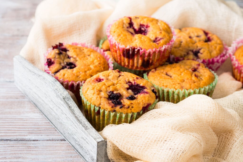 Muffins de amora em caixa de madeira com pano claro