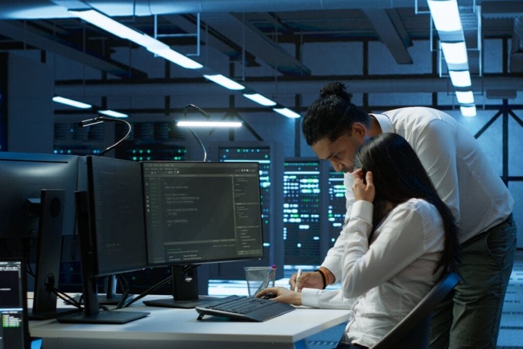 Homem e mulher em um escritório mexendo em um computador 