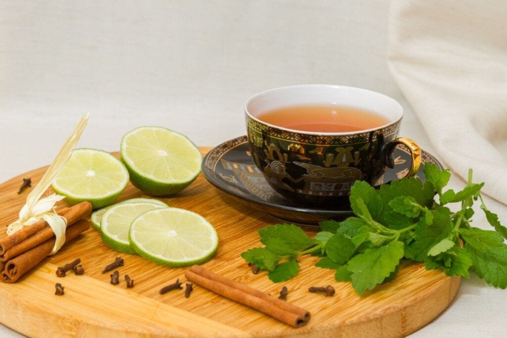 Xícara com chá de erva-cidreira com limão e canela em pau