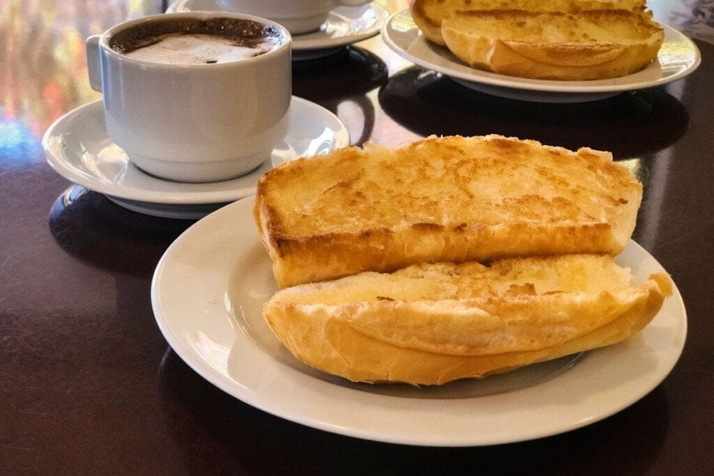 Pão francês torrado e cortado ao meio e em cima de um prato branco