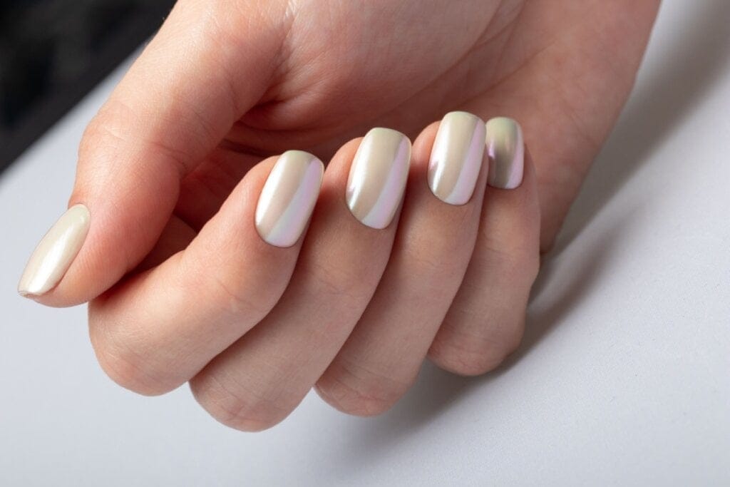 mão com unhas em tom de amarelo perolado