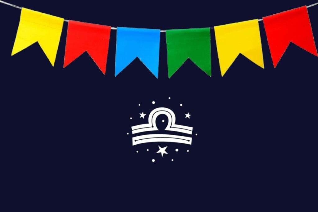 Ilustração do signo de Libra com semicírculo acima de duas linhas retas brancas, fundo azul-escuro e bandeirinhas vermelhas, azul, verde e amarelas