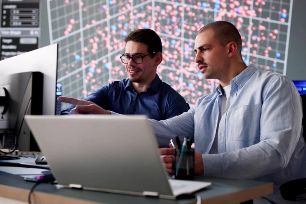 Dois homens trabalhando com computador e notebook