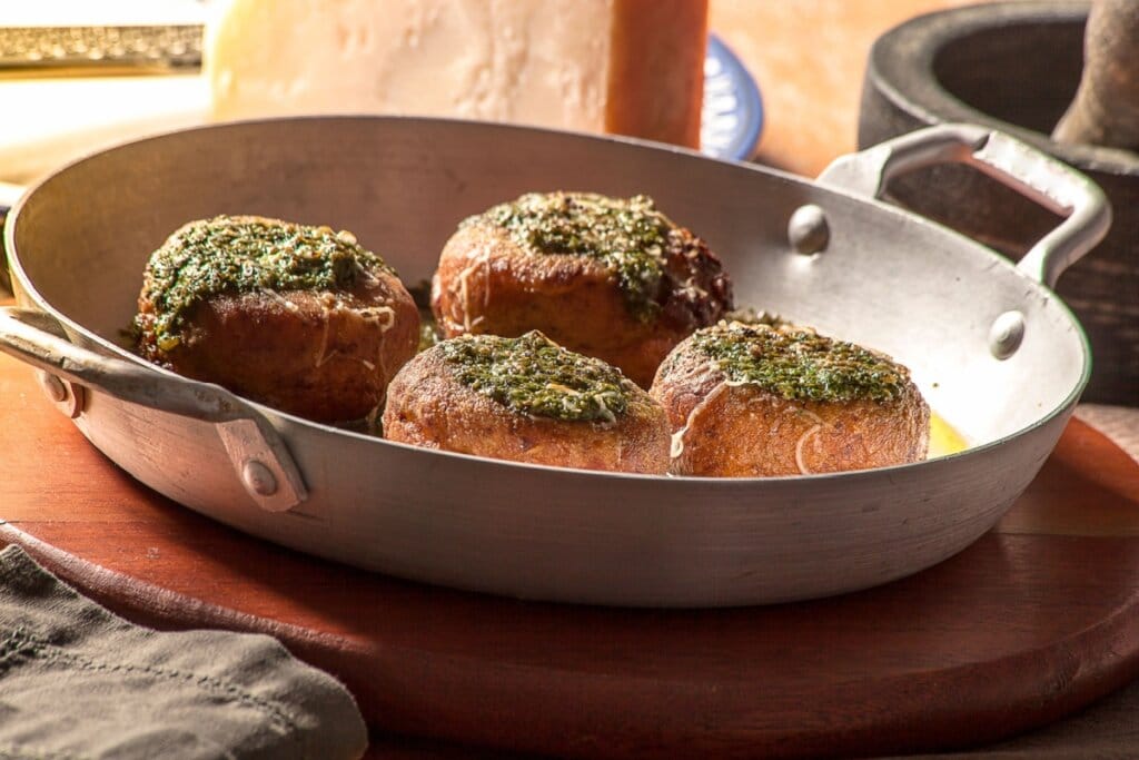 Polpetones recheados com queijo e ao molho de ervas dentro de uma panela de metal