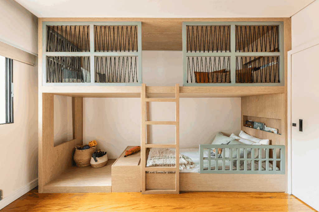 Quarto com cama baixa em madeira  em cor natural e verde e na parte de cima um espaço de leitura com almofadas coloridas