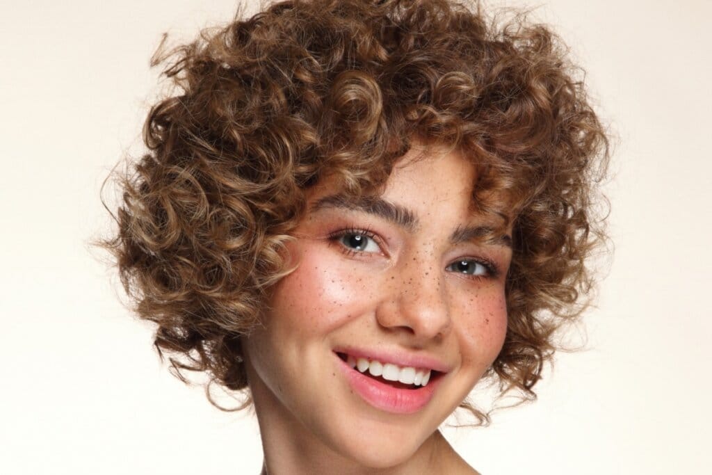 Mulher sorrindo usando blush rosa na bochecha