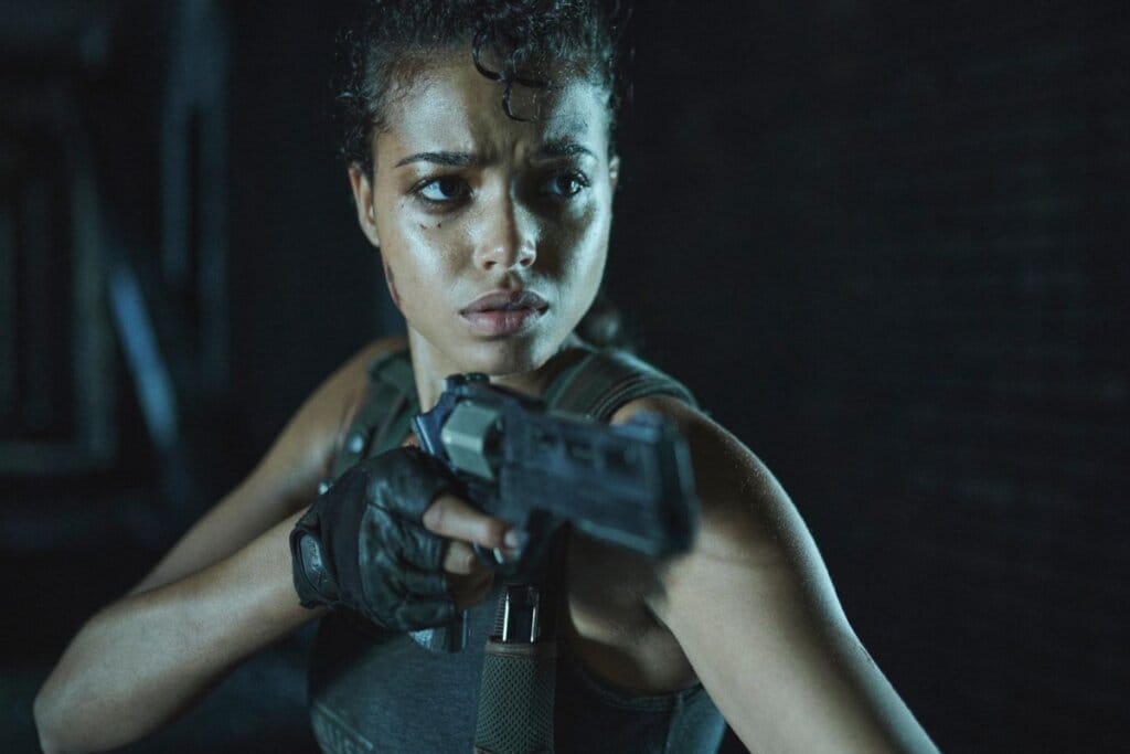 Cena de uma mulher segurando uma arma em "Resident Evil"