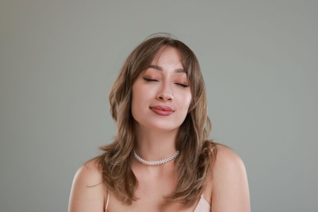 mulher com cabelo loiro em camadas e olhos fechados