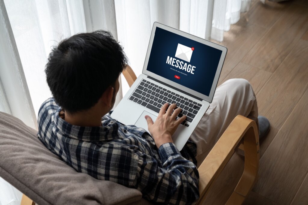 Homem usando notebook com mensagem suspeita na tela