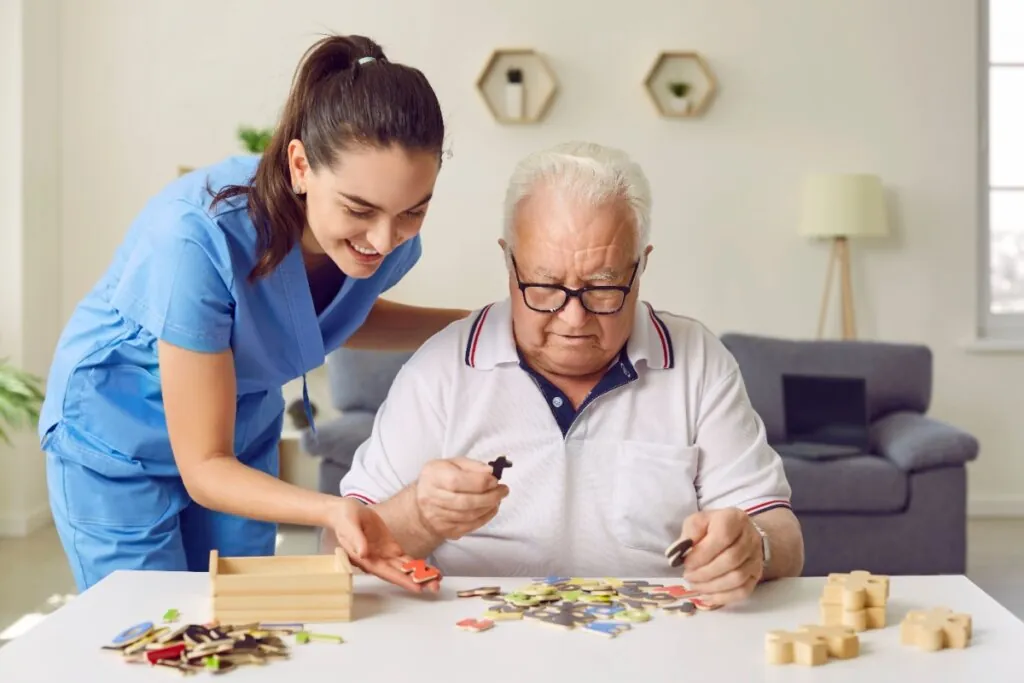 Enfermeira jogando quebra-cabeça junto a idoso 