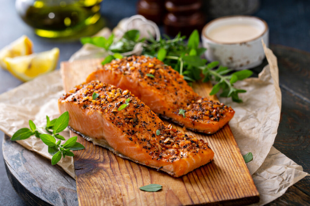 Salmão grelhado com ervas em tábua de madeira