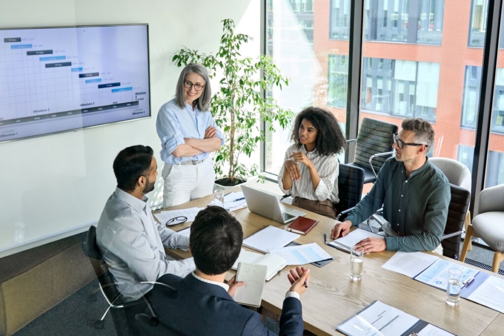 Equipe de trabalho em reunião em escritório, todos estão usando roupas sociais
