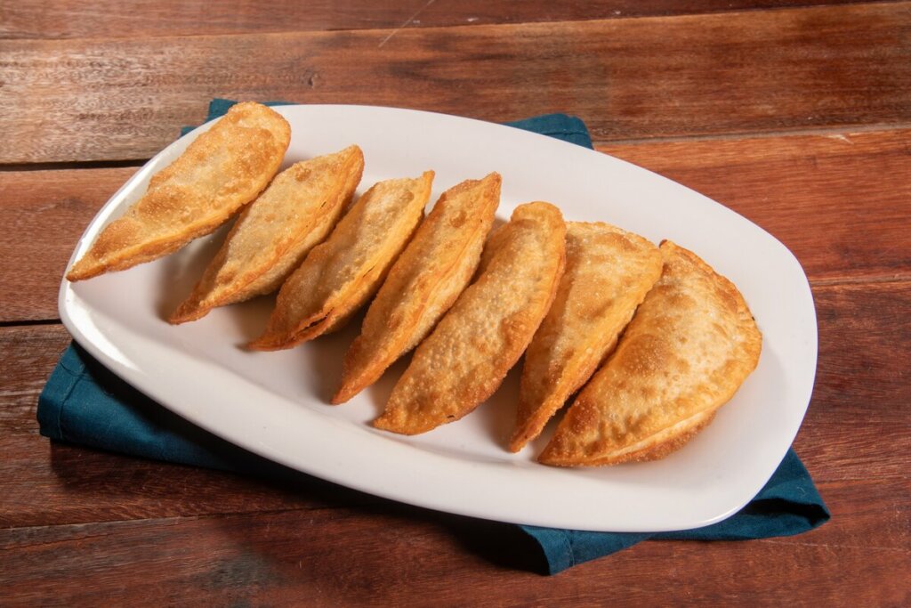 Prato branco com pastéis em cima de uma mesa de madeira