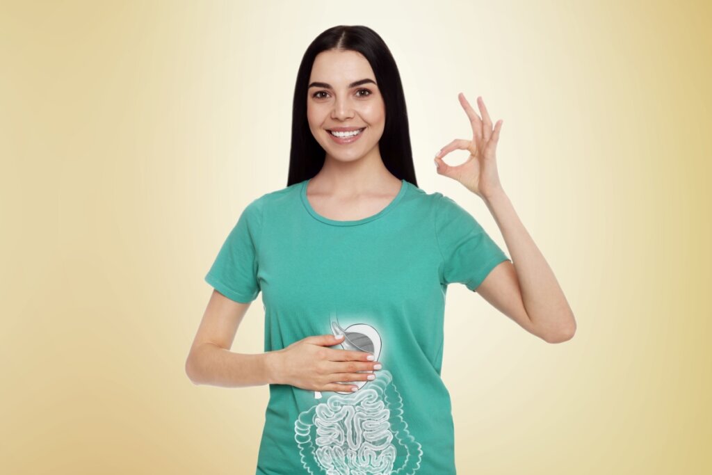 Jovem fazendo o sinal de ok com a mão e a outra mão está na barriga indicando um intestino saudável