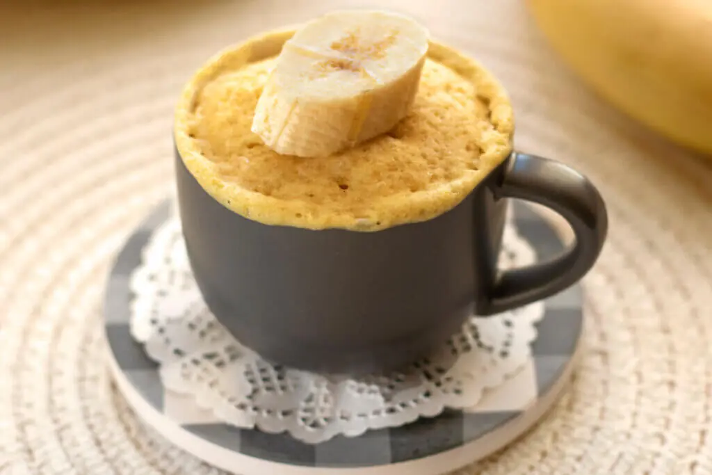 Bolo em uma caneca cinza decorado com um pedaço de banana