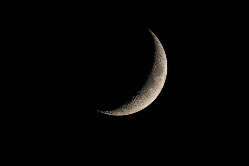 imagem de lua em fase minguante sobre fundo preto