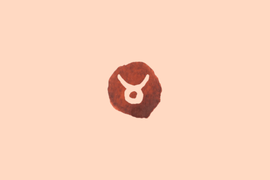Ilustração do signo de Touro sobre fundo uniforme em tom pêssego-claro. No centro, há uma mancha circular irregular em marrom-avermelhado, com textura manchada semelhante à aquarela. Sobre ela, o símbolo de Touro aparece em tom creme, com duas linhas curvas voltadas para cima, que se unem a uma forma arredondada na parte inferior, lembrando a cabeça e os chifres de um touro.