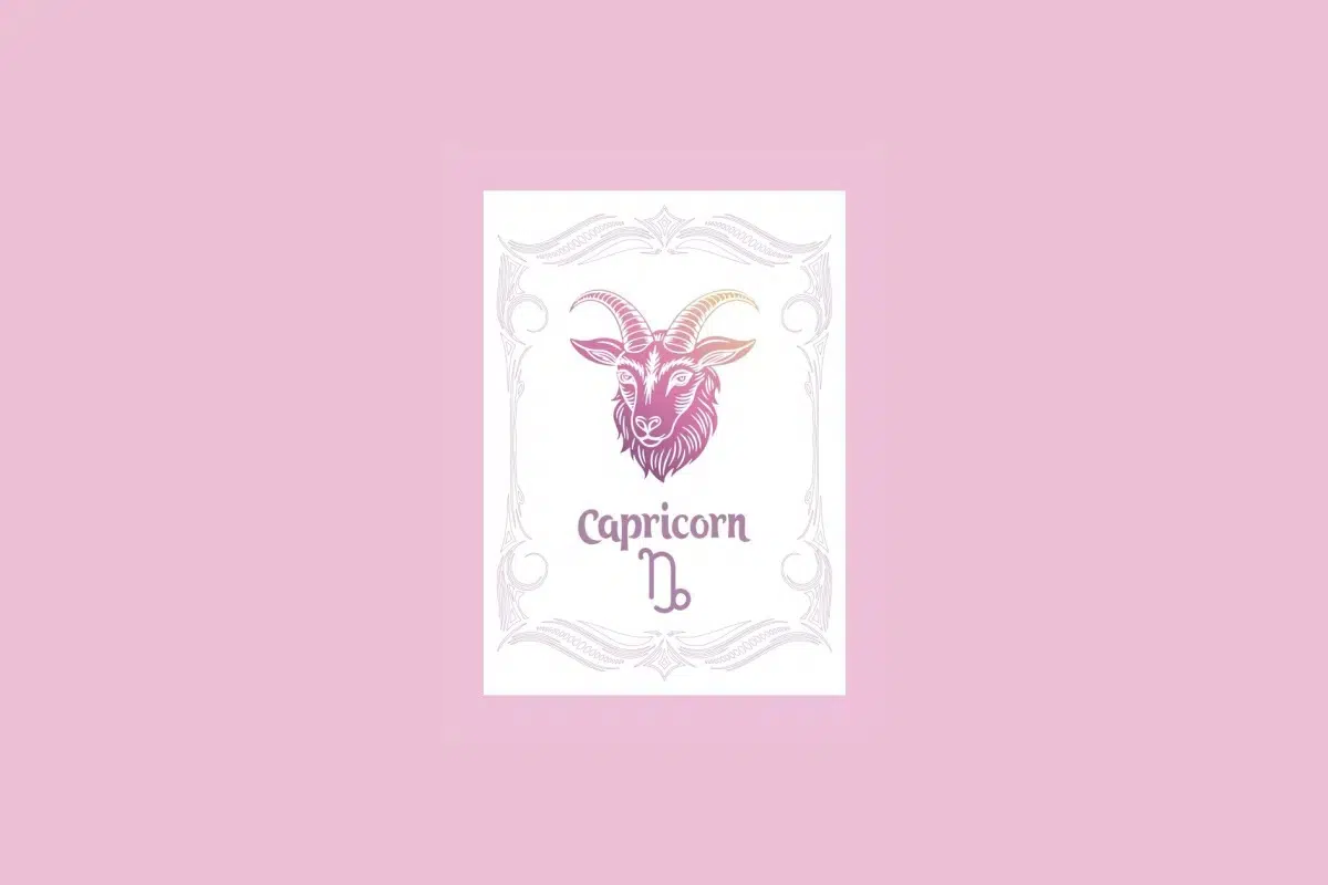 Um cartão branco com uma moldura ornamentada em rosa claro contém a ilustração de uma cabeça de cabra com um gradiente de roxo a laranja, e o texto "Capricorn" acima do símbolo da cabra, tudo sobre um fundo rosa sólido.