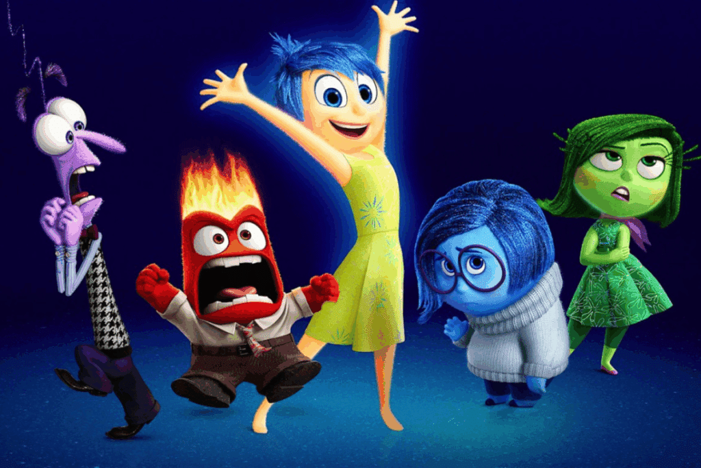 Os cinco personagens das emoções do filme "Divertida Mente" em um fundo azul. No centro, a Alegria de vestido amarelo com braços abertos; à esquerda, o Medo roxo e a Raiva vermelha e brava; à direita, a Tristeza azul de óculos e a Nojinho verde com os braços cruzados.